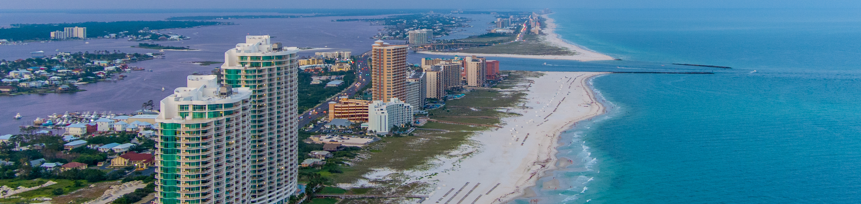 High-rise buildings in closeup with a blurred background of the coastline and ocean along Alabama's Gulf Shores.