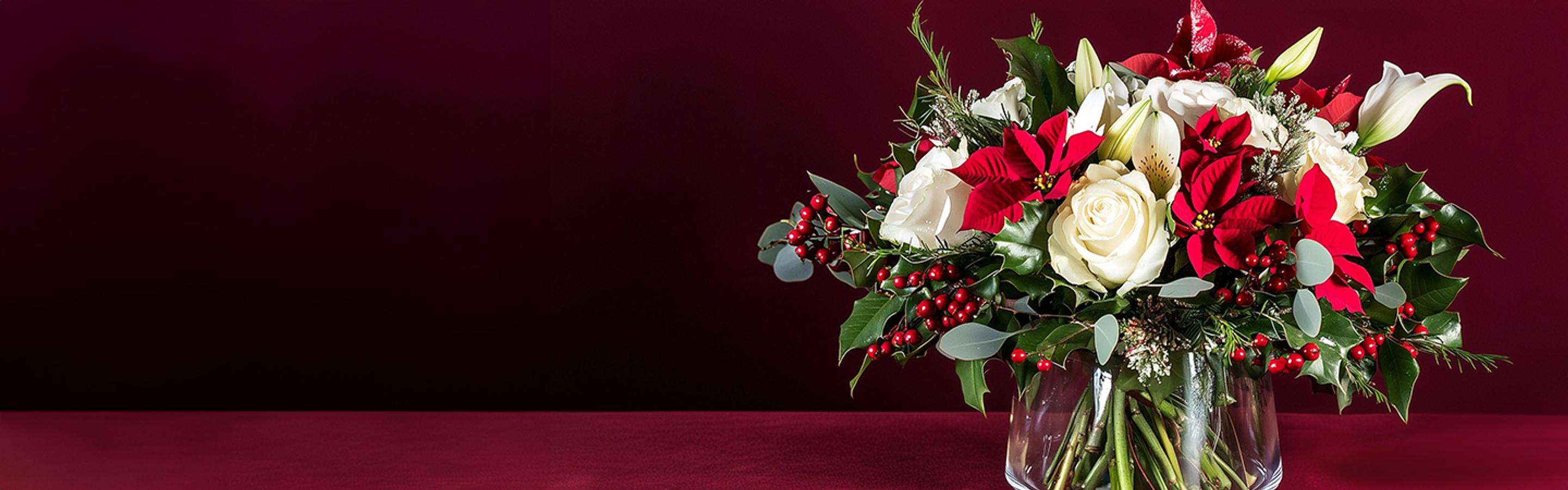 a vase filled with red and white flowers and berries on a table .