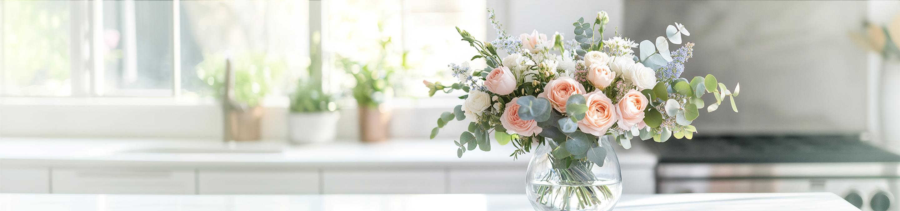 a vase filled with flowers is sitting on a kitchen counter .