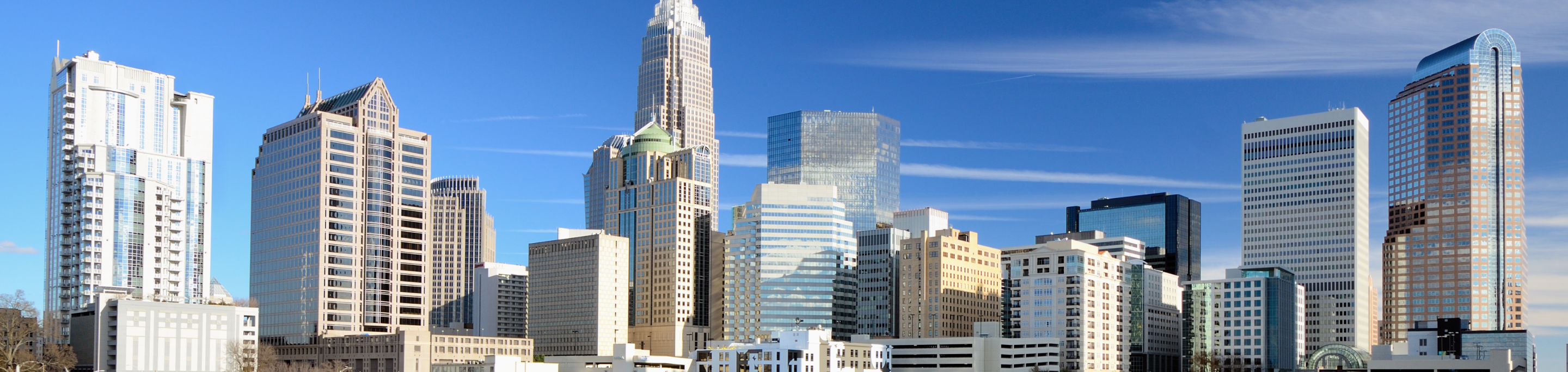 The Charlotte skyline in closeup with a blurred background of modern skyscrapers under a clear blue sky in North Carolina.