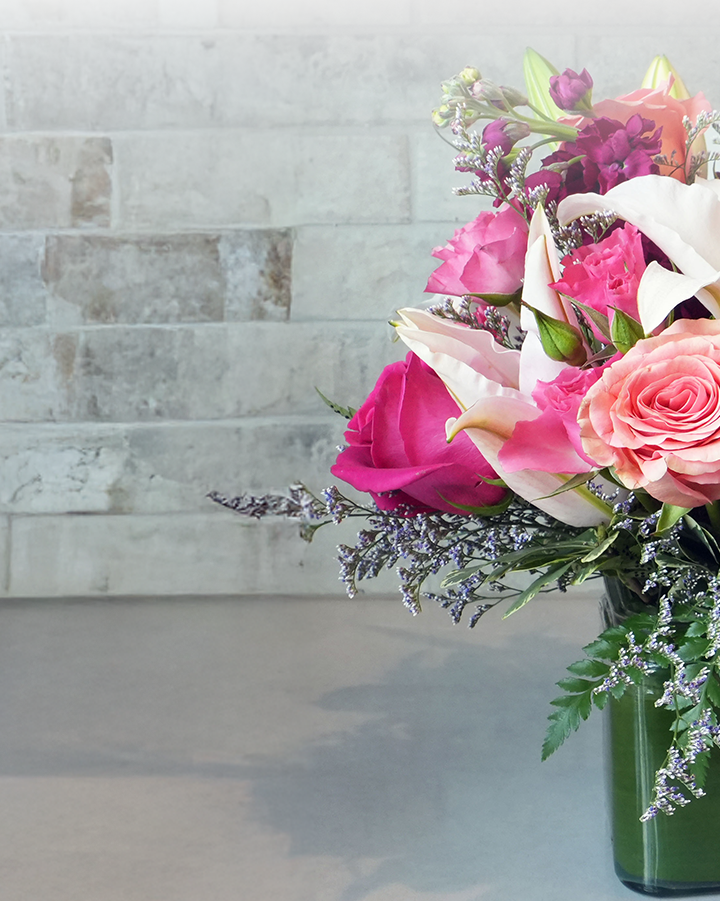 a vase filled with pink and white flowers sits on a table