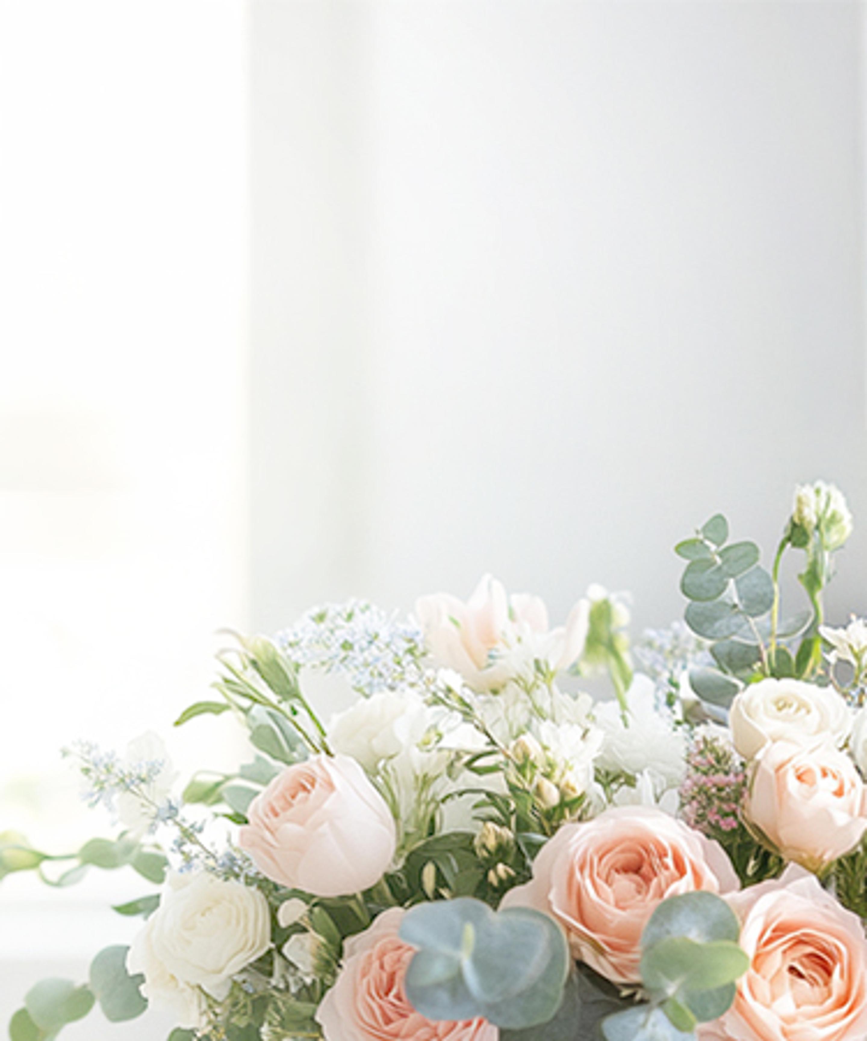 a bouquet of flowers is sitting on a table in front of a window .