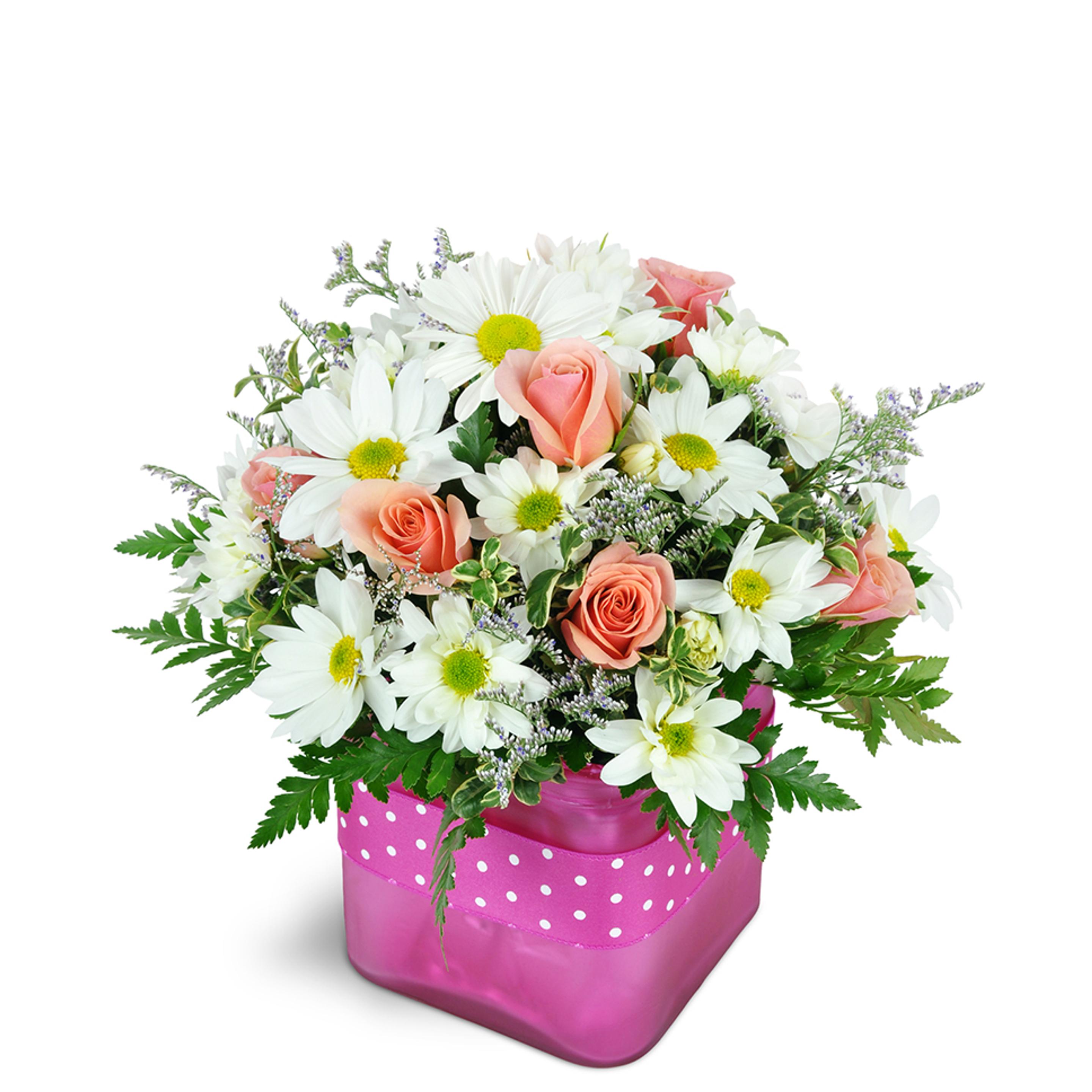 Fun floral arrangement featuring peach roses and white daisies in a bright pink polka-dotted vase.