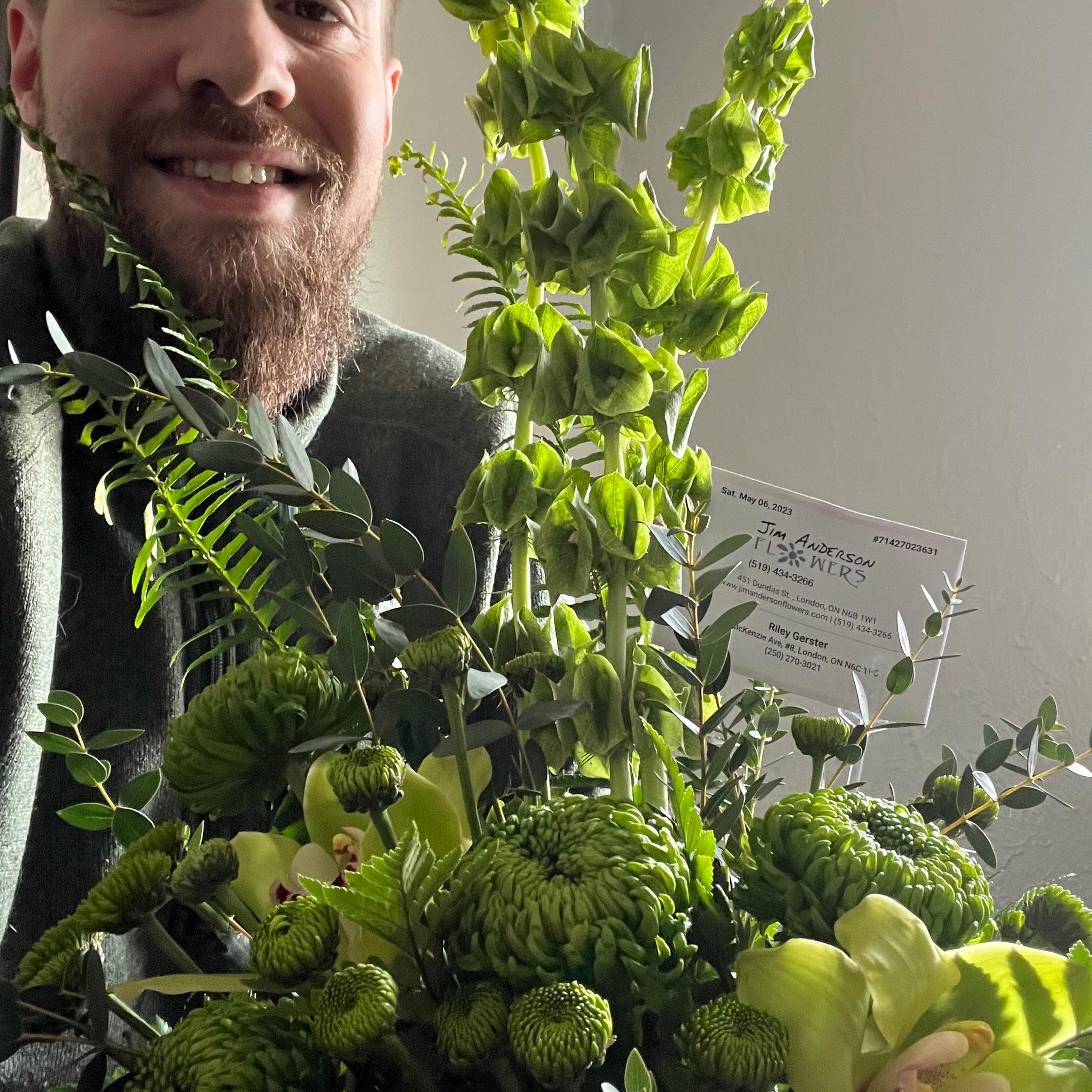 Man with beard holding a bright green arrangement