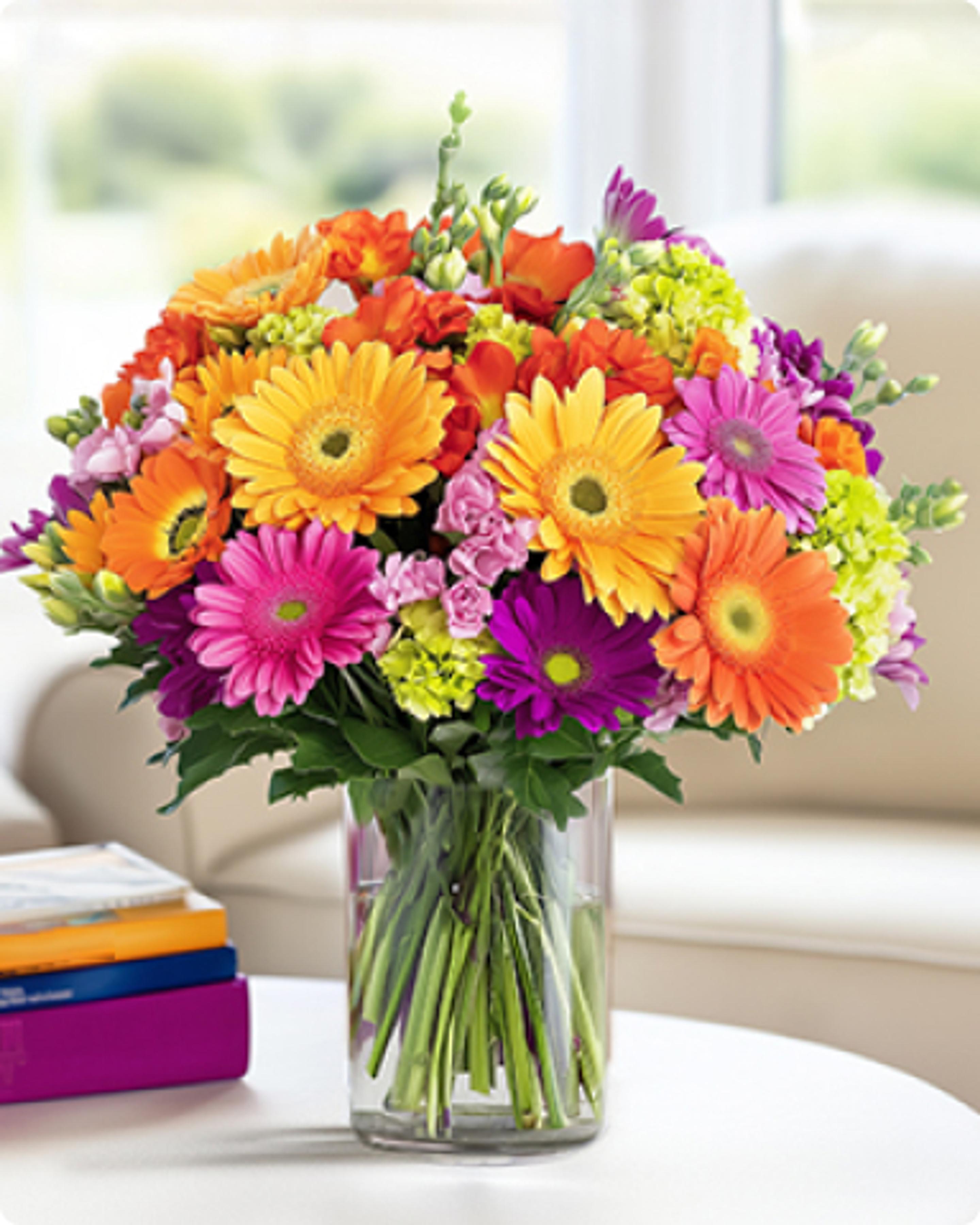 a vase filled with colorful flowers is sitting on a table .