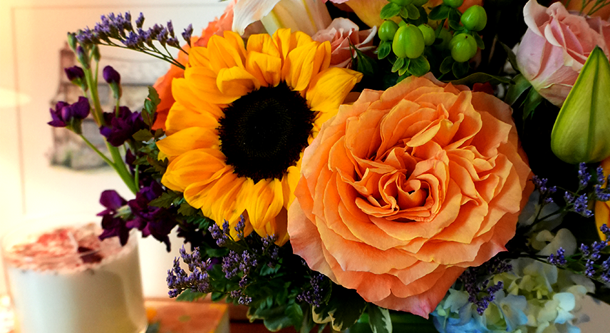 a bouquet of fall flowers including sunflowers and roses
