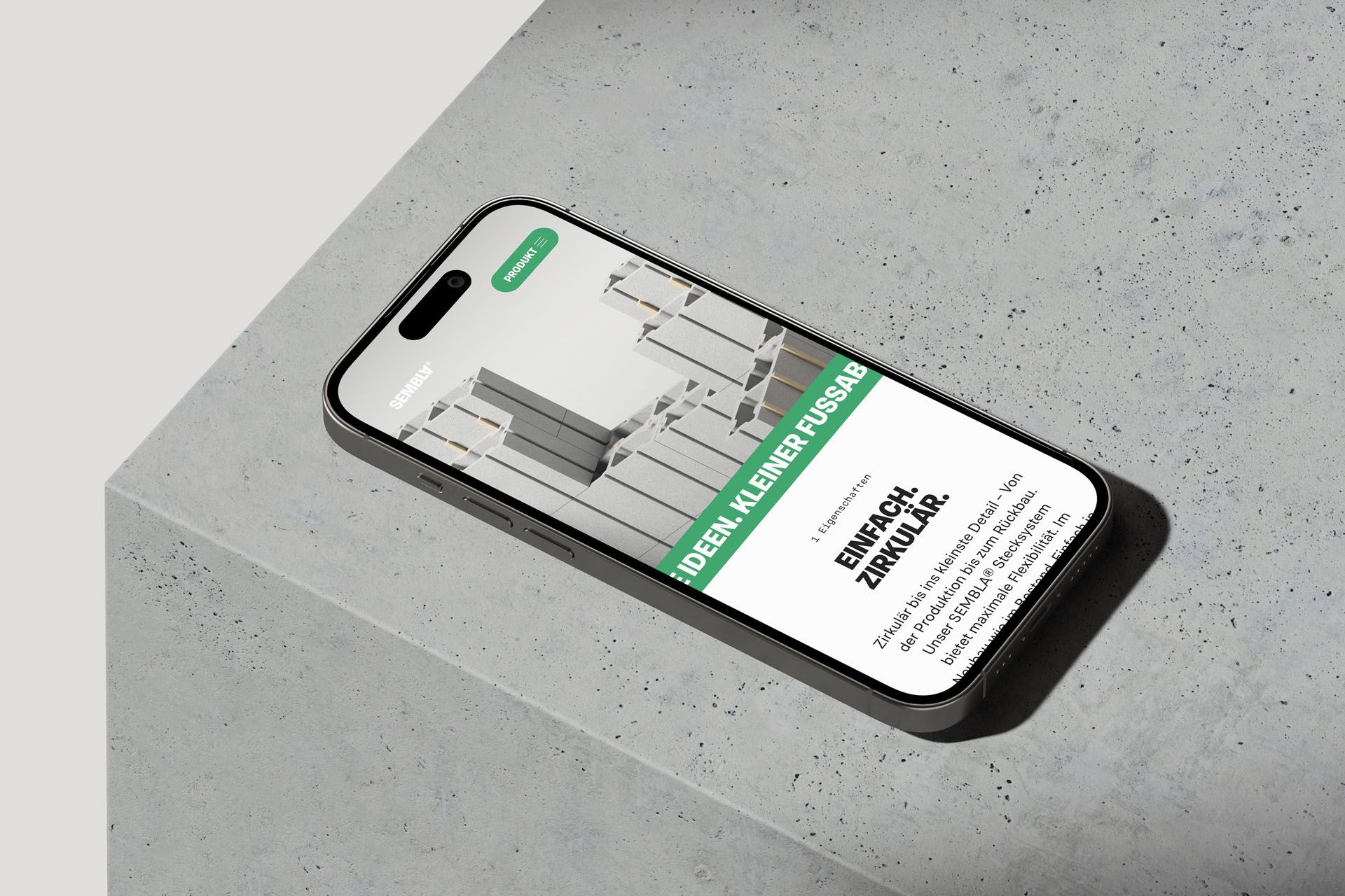 Smartphone laying on concrete surface displaying the mobile stage of the product website