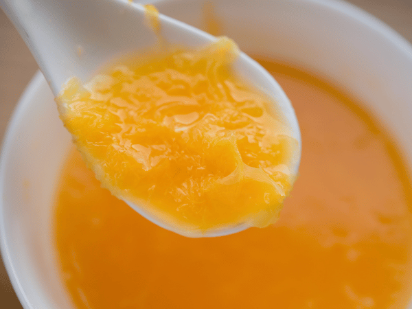 A bowl of cooked, unseasoned, pureed pumpkin which is one of the safe food for cats as treats
