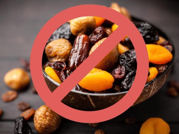 An image of dried fruits with raisins which is a toxic food for dogs, overlaid with a prohibition sign to represent that this isn’t safe food for dogs