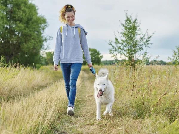 A dog parent happily walking with their fur baby after a successful dog adoption in Denver