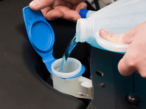 Closeup of antifreeze that is carefully poured so that it does not spill and endanger pets. This is one of the most important cold weather pet safety tips