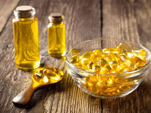 Bowls and bottles containing fish oil for cats or omega-3 supplements for cats