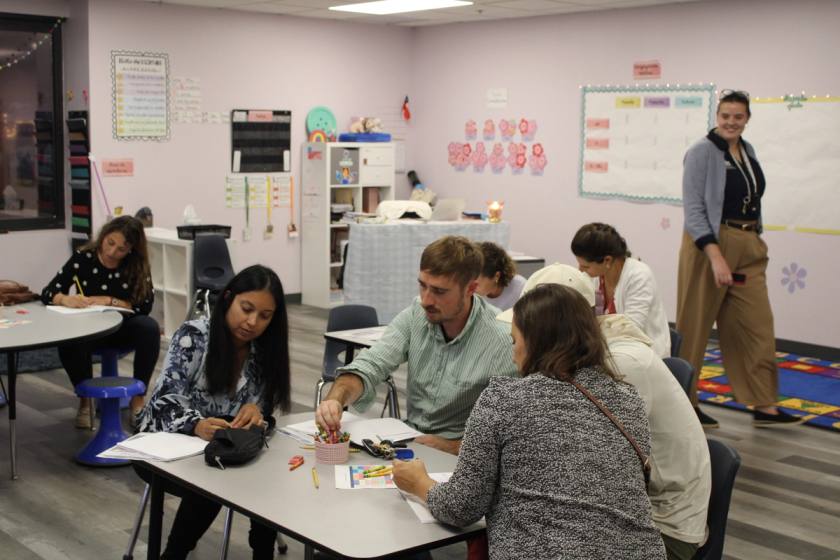 Current SELA parent's sitting in a Kindergarten classroom writing letters to their children in spanish. 