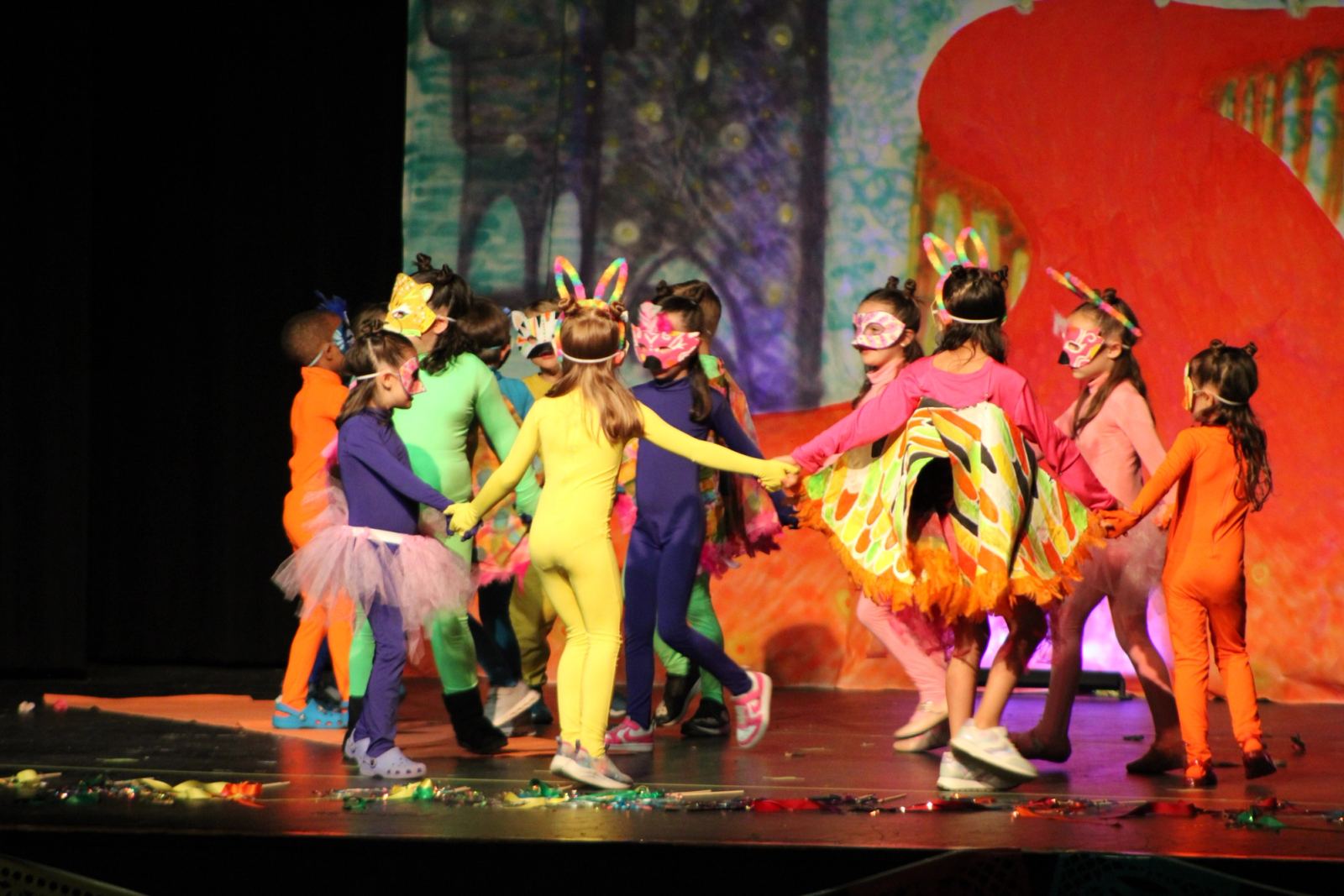 SELA students on stage holding hands during their performance of Coco in Spanish