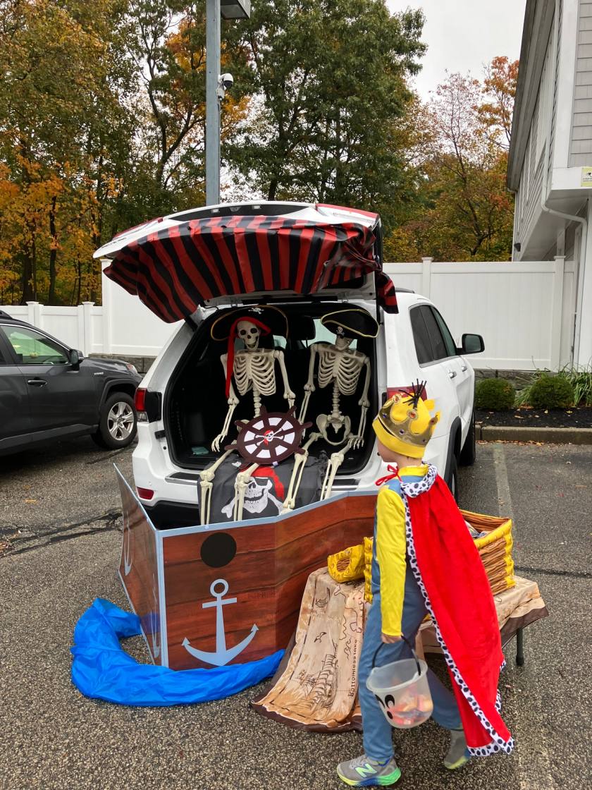 Trunk or Treat decoration at SELA's Norwell Campus. Trunk is decorated as a pirate ship and there is a child dressed up as a king getting candy.