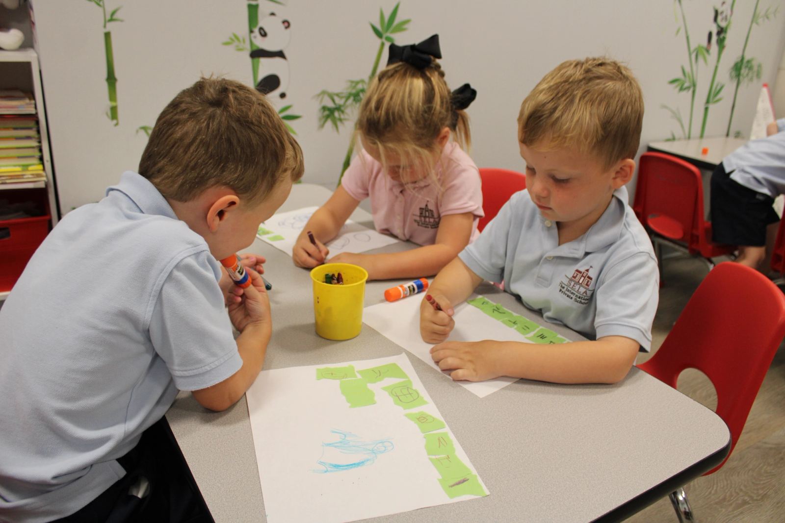 Three SELA JuniorK students in Mandarin class practicing numbers 1 through 10. 