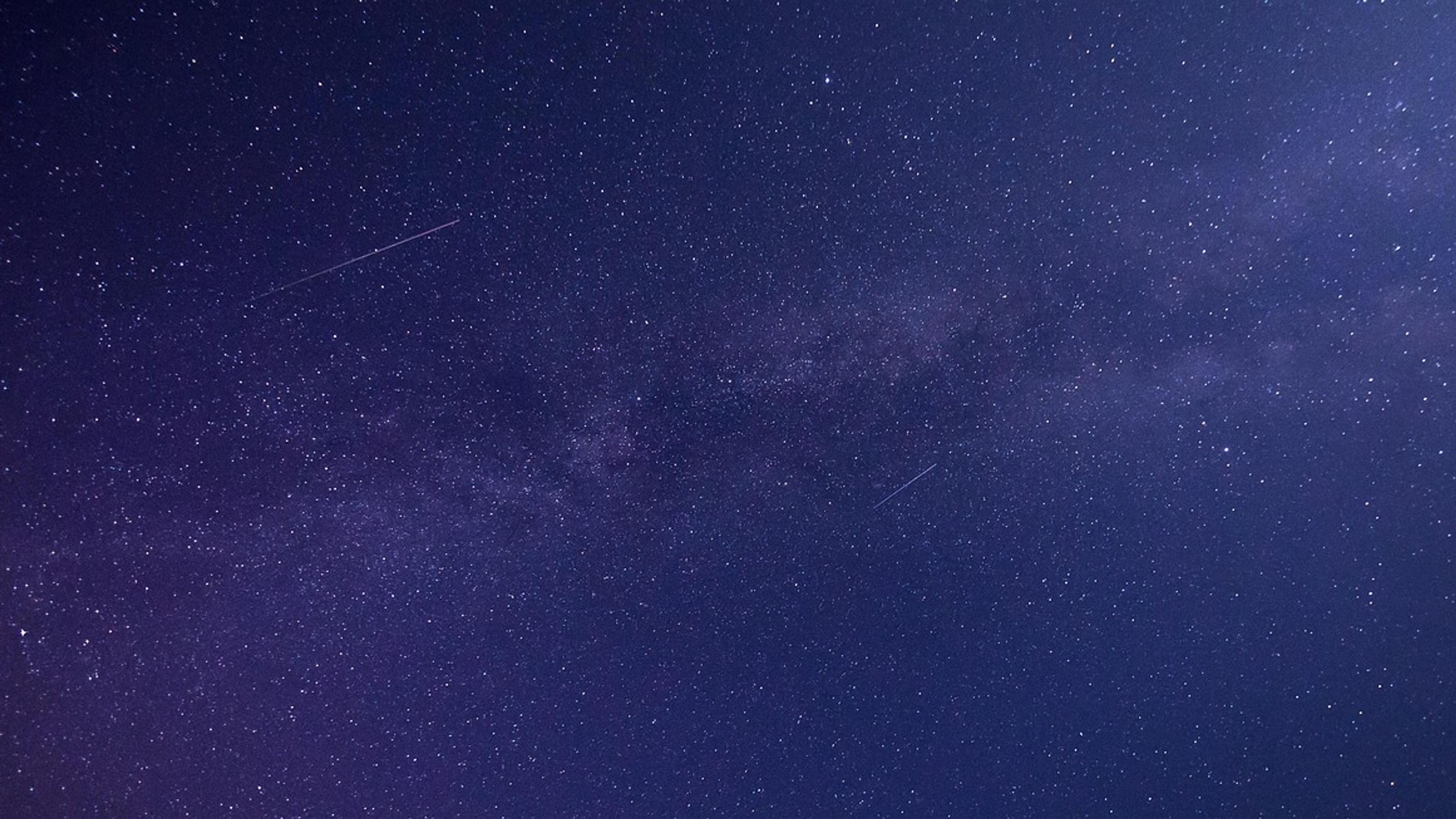 The Milky Way stretching across a dark blue starry night sky