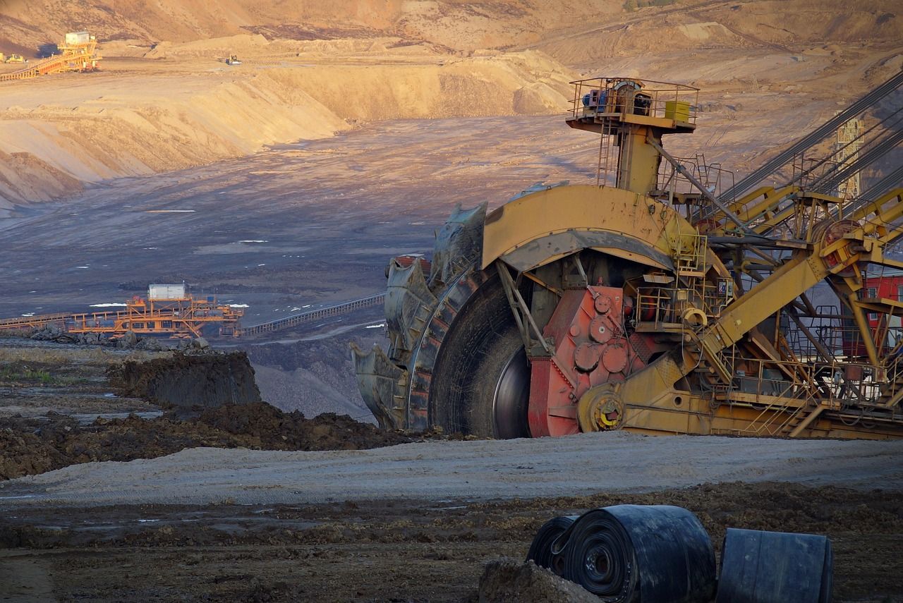 A large bucket-wheel excavator in an open-cut coal mine at dusk