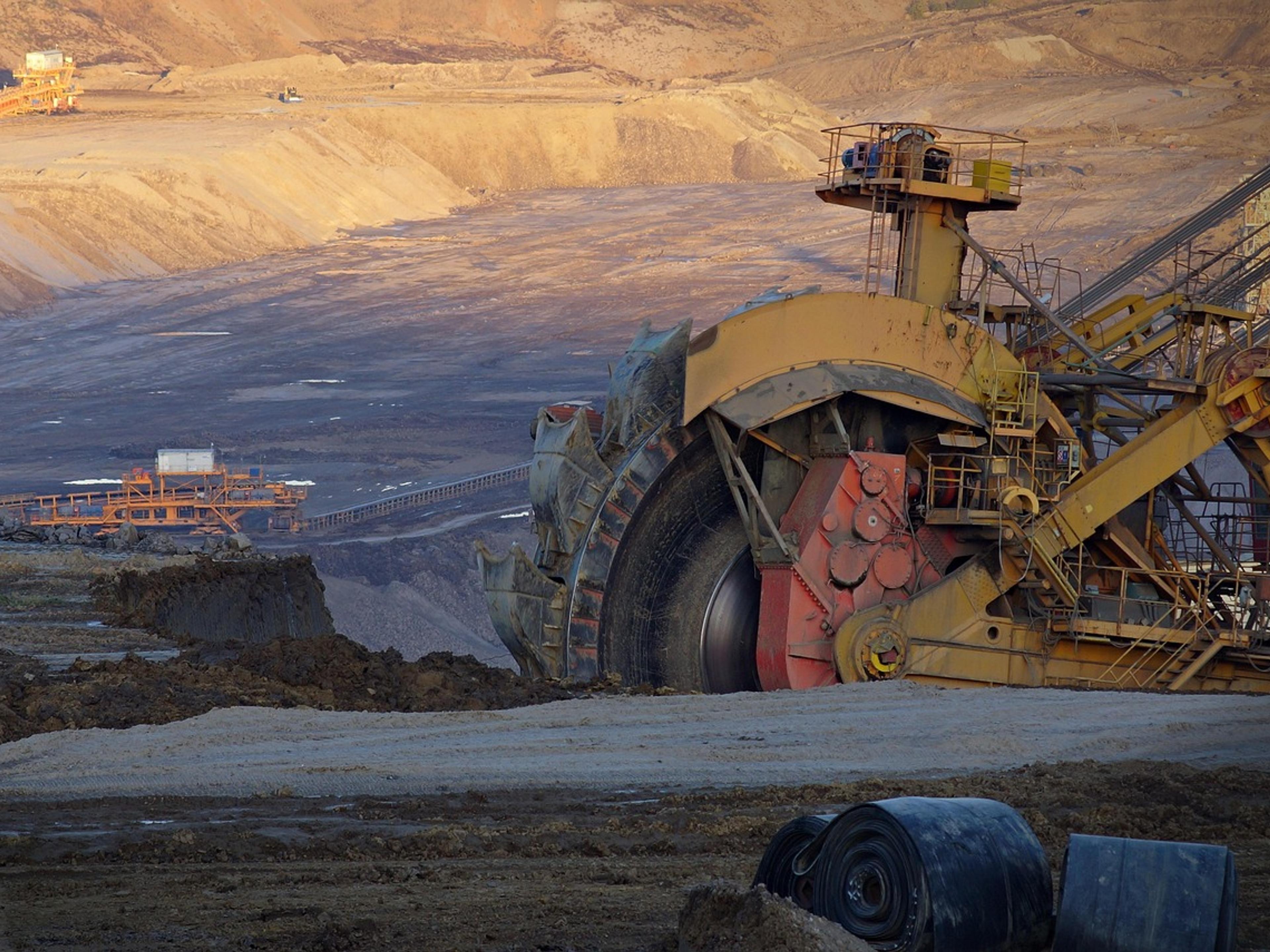 A large bucket-wheel excavator in an open-cut coal mine at dusk