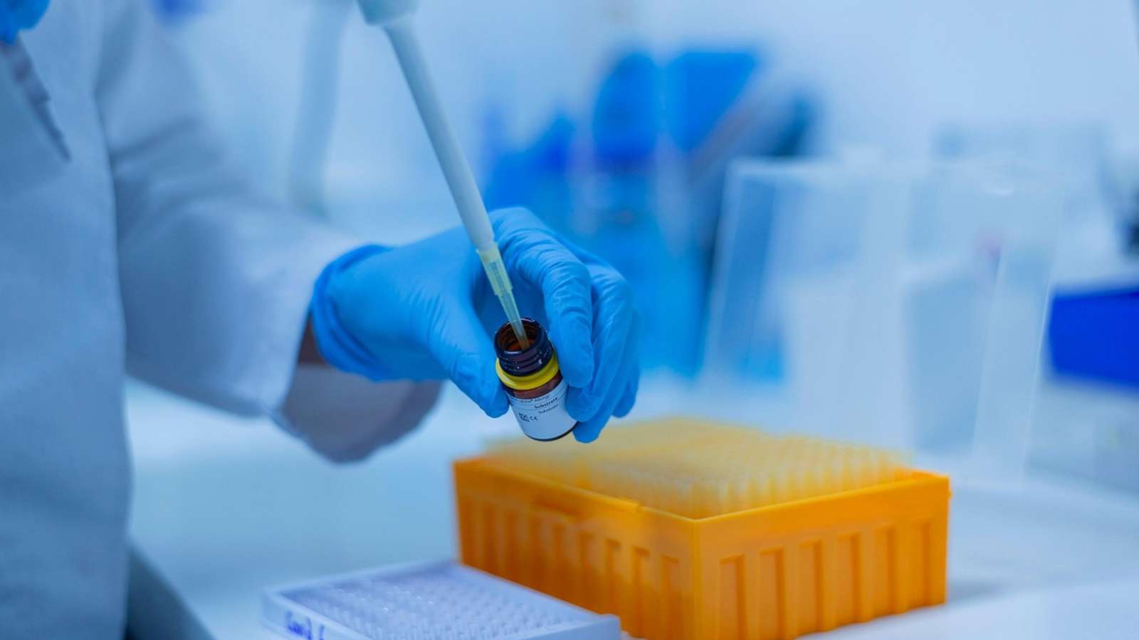 A scientist using a pipette in a laboratory