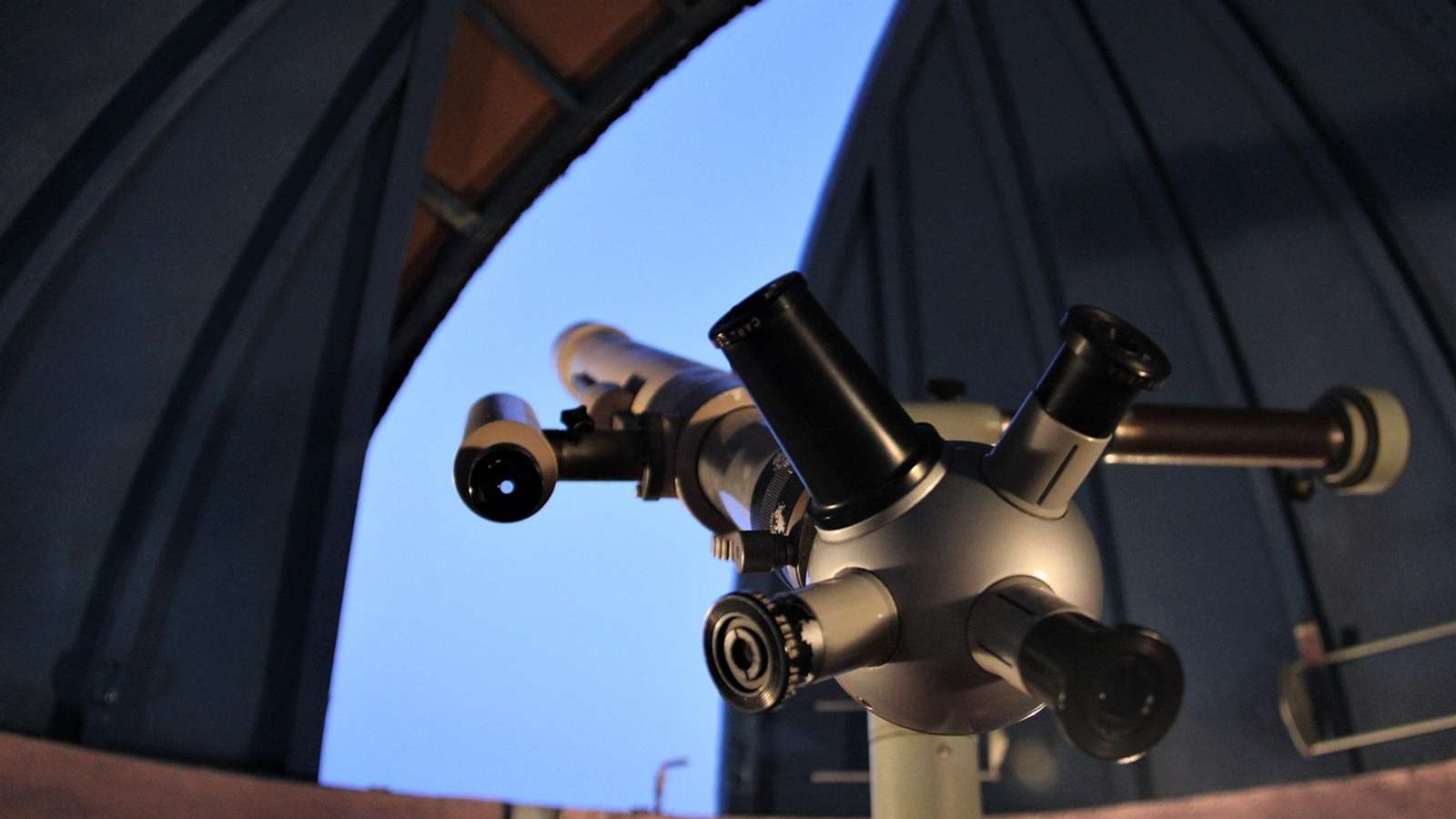 An astronomical observatory dome under a starry night sky