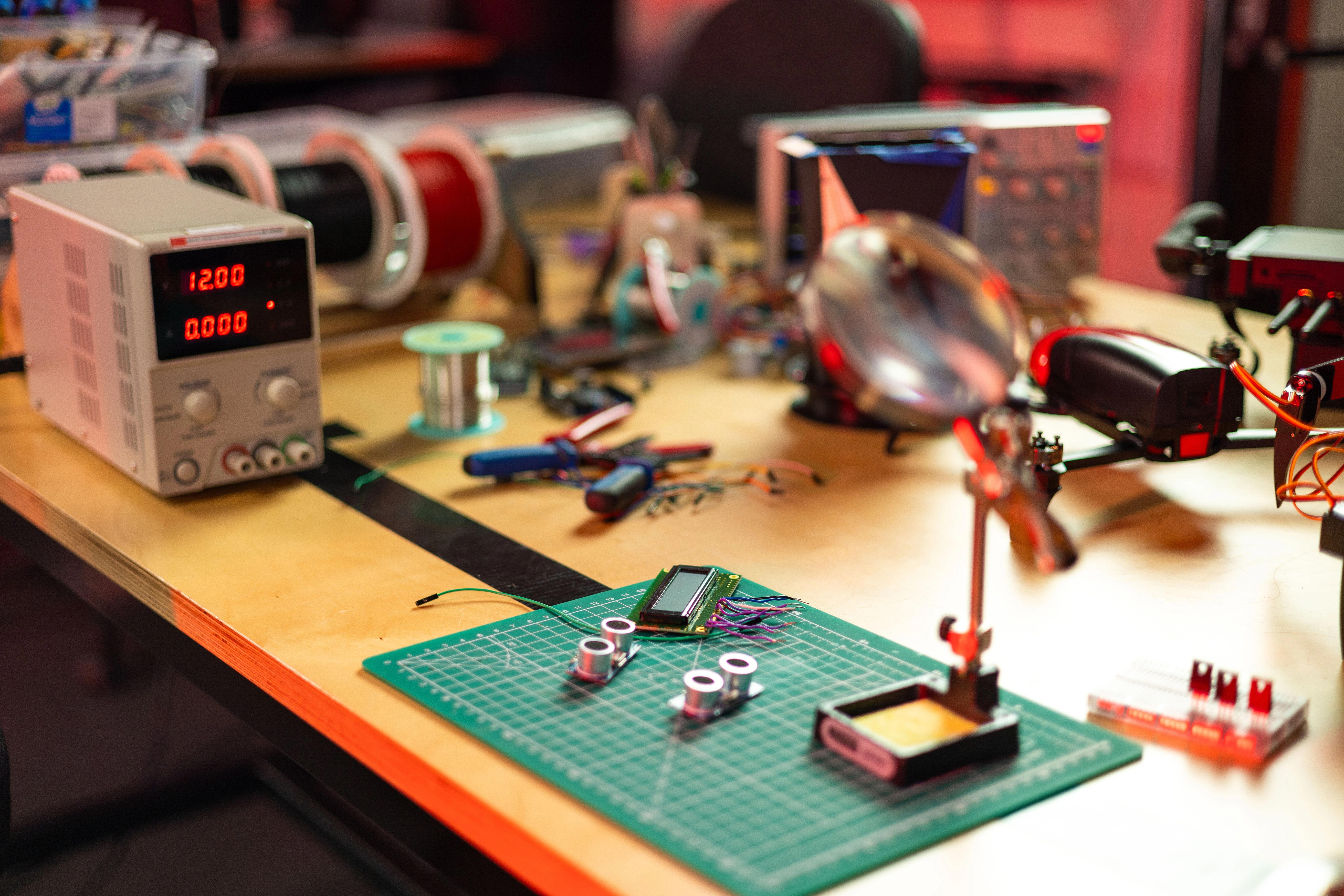 An electronics workbench with circuit boards, soldering tools, and precision instruments, representative of the prototyping work behind the new modular building blocks.