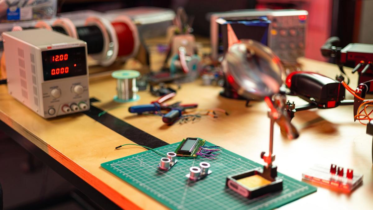 An electronics workbench with circuit boards, soldering tools, and precision instruments, representative of the prototyping work behind the new modular building blocks.