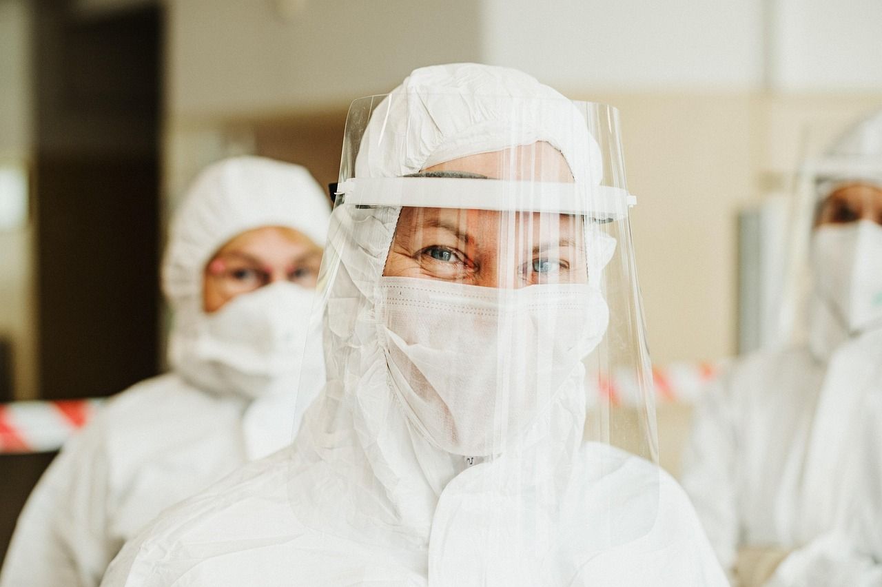 A health worker in a protective suit and face shield
