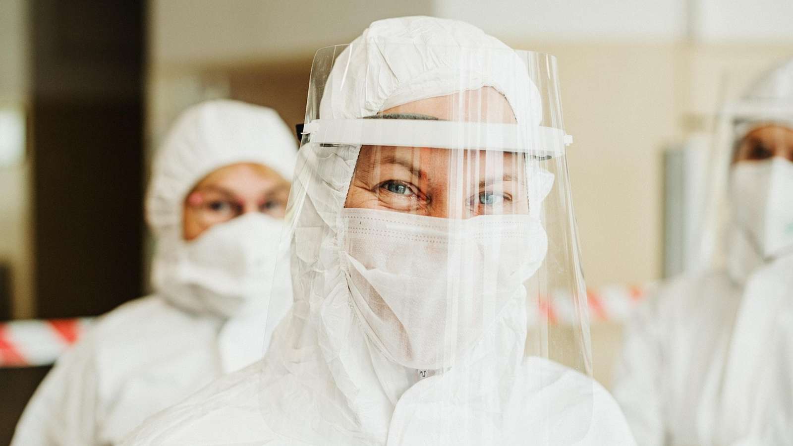 A health worker in a protective suit and face shield