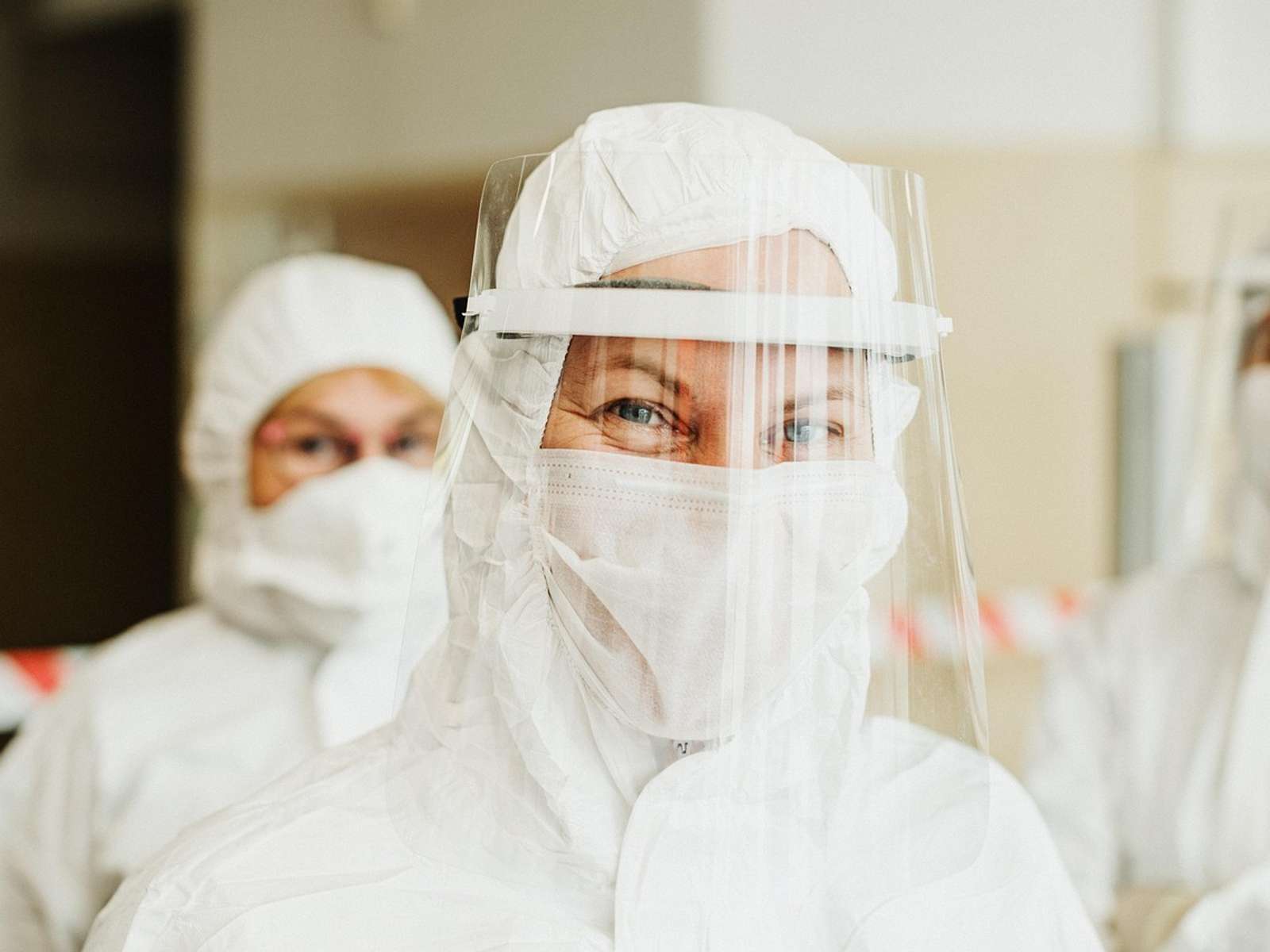 A health worker in a protective suit and face shield