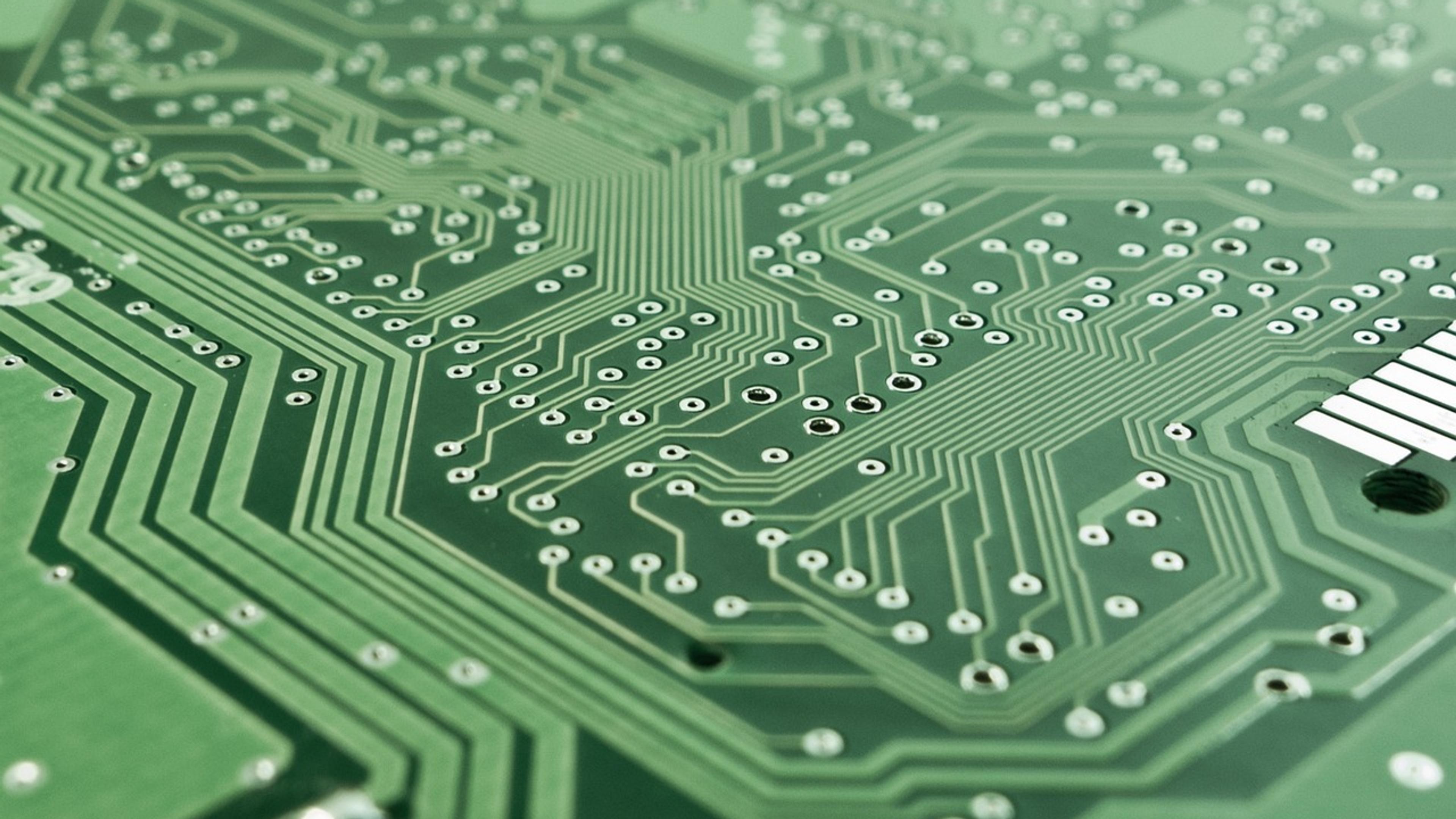 Close-up of a green printed circuit board with electronic components