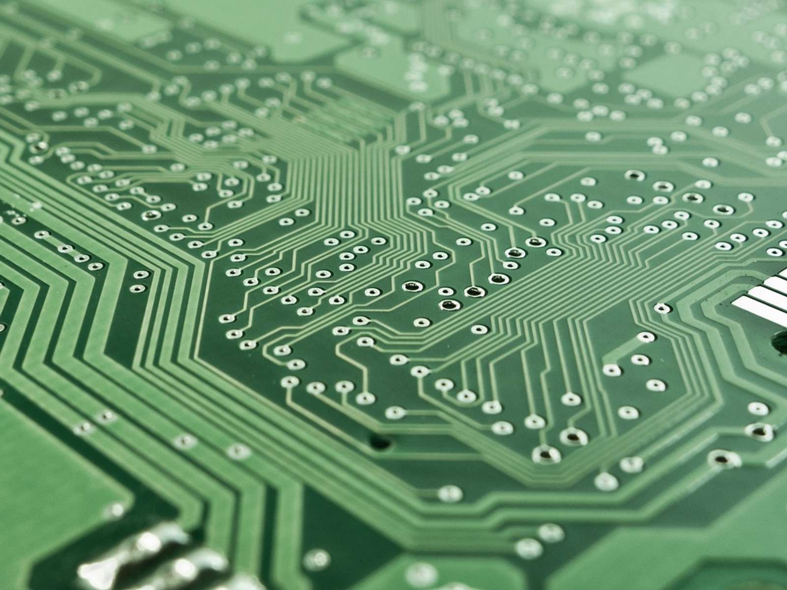 Close-up of a green printed circuit board with electronic components