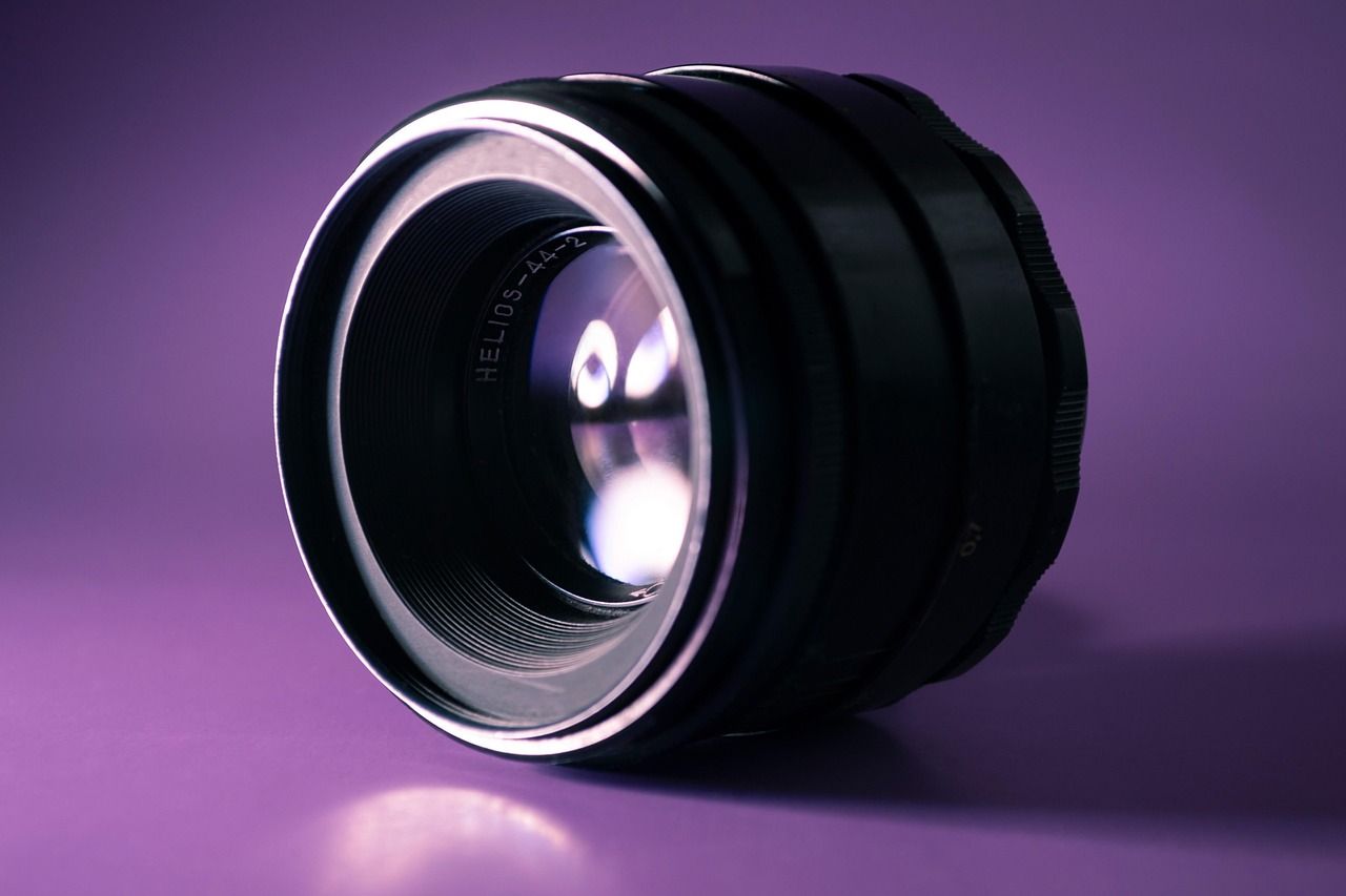Close-up of a precision optical lens lit against a purple background