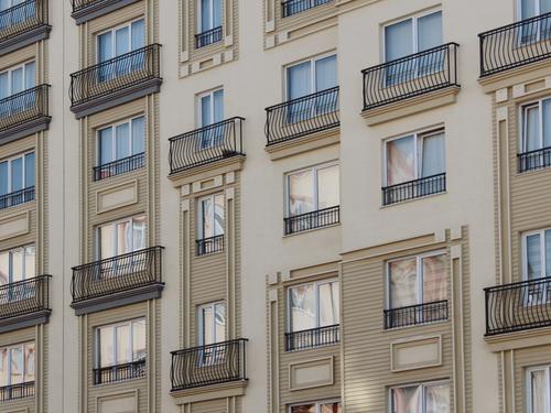 Contemporary apartment buildings with balconies and green landscaping in daylight