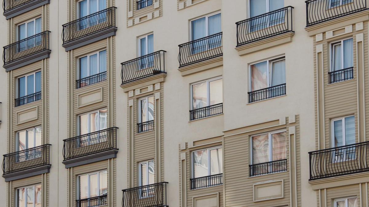 Contemporary apartment buildings with balconies and green landscaping in daylight