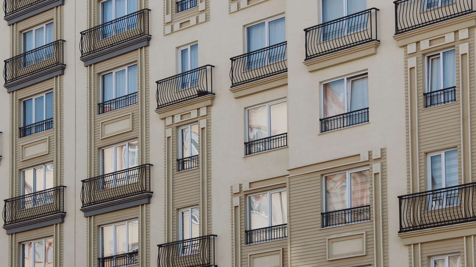 Contemporary apartment buildings with balconies and green landscaping in daylight