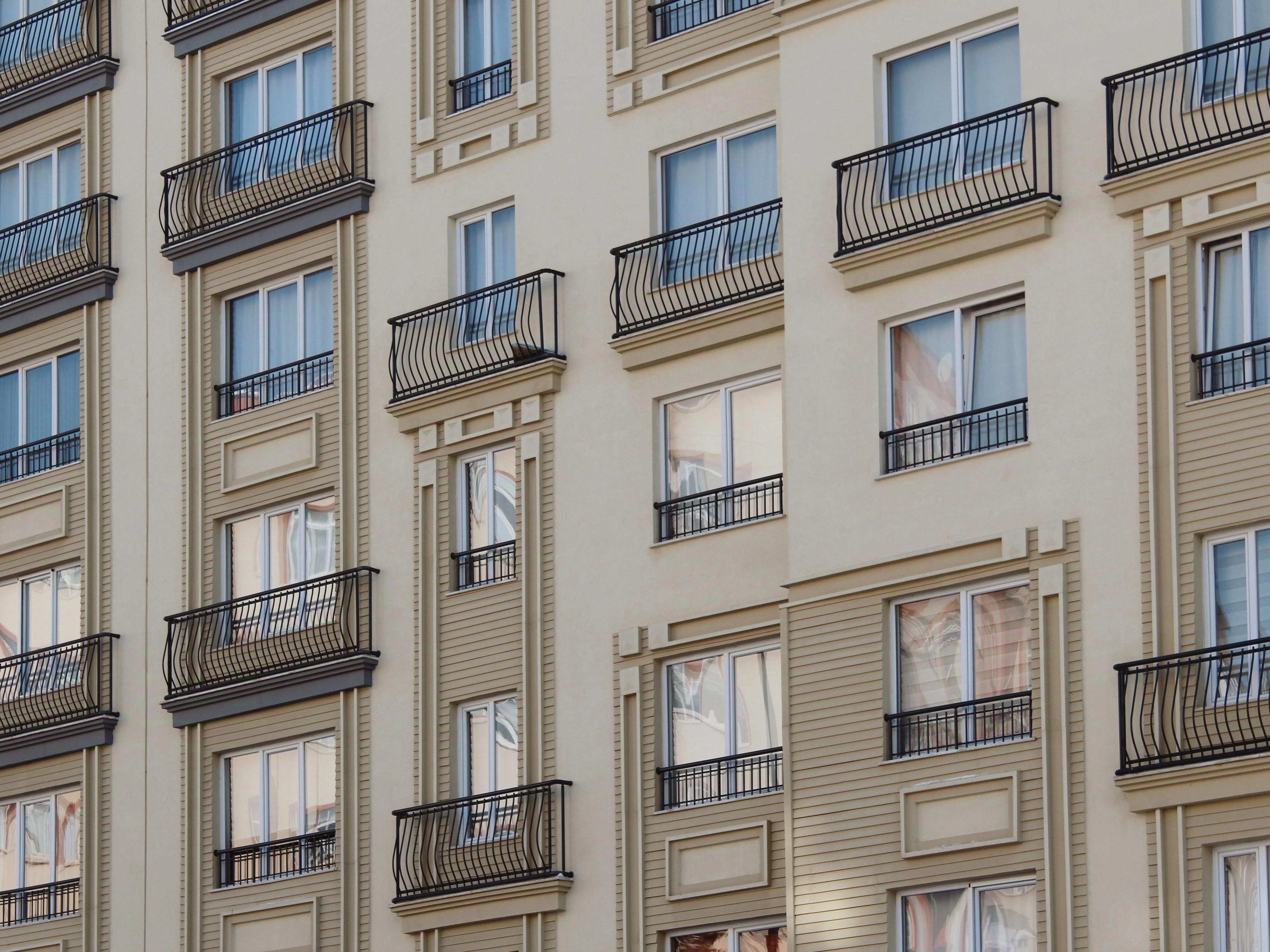 Contemporary apartment buildings with balconies and green landscaping in daylight