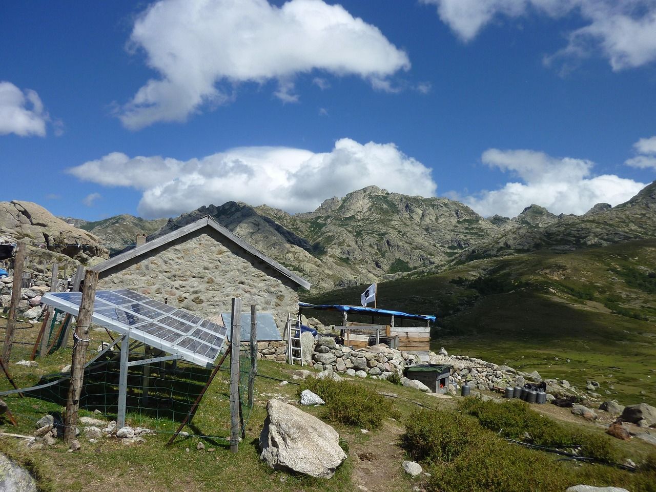 A solar panel beside a rural hut on a hilltop