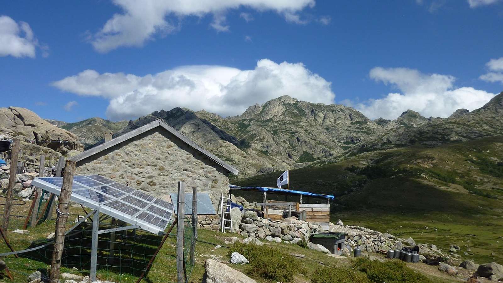 A solar panel beside a rural hut on a hilltop