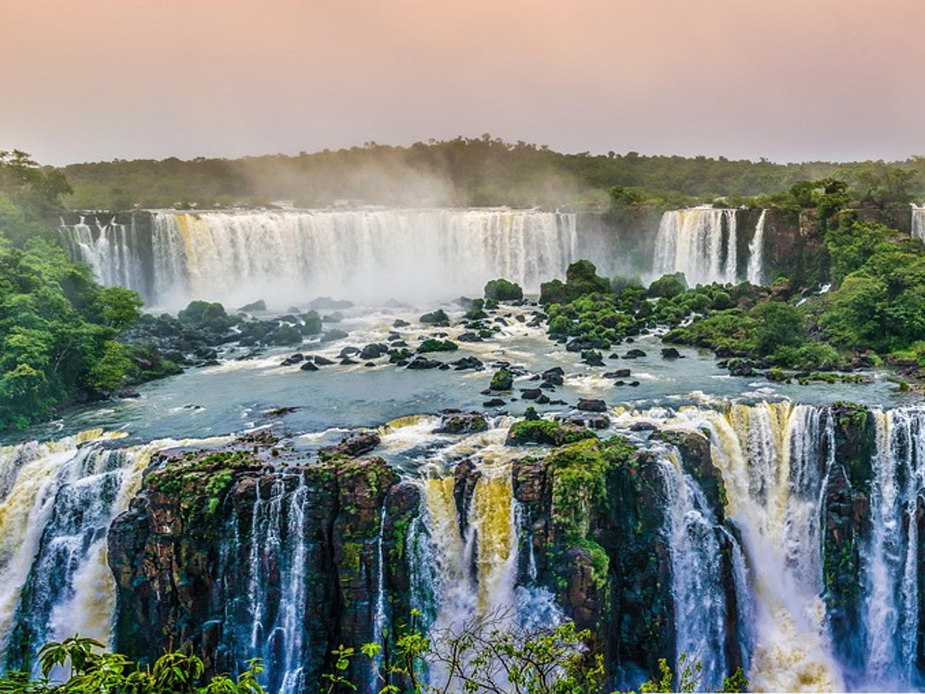 Wide waterfalls cascading through green rainforest