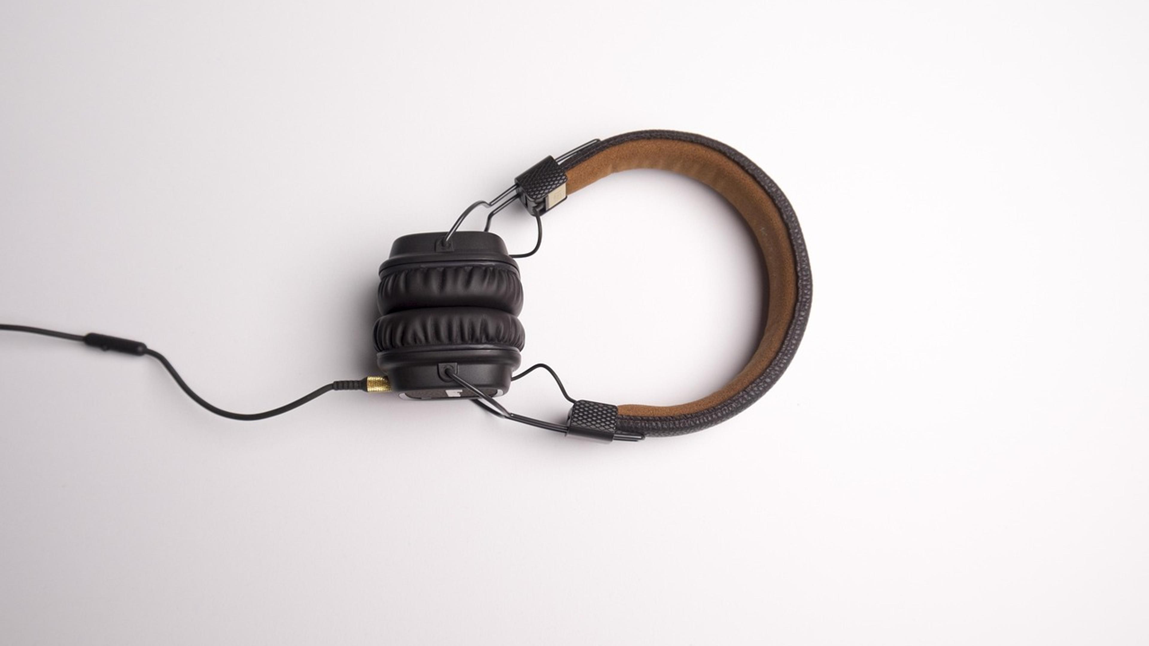 A pair of headphones with a cable on a white surface
