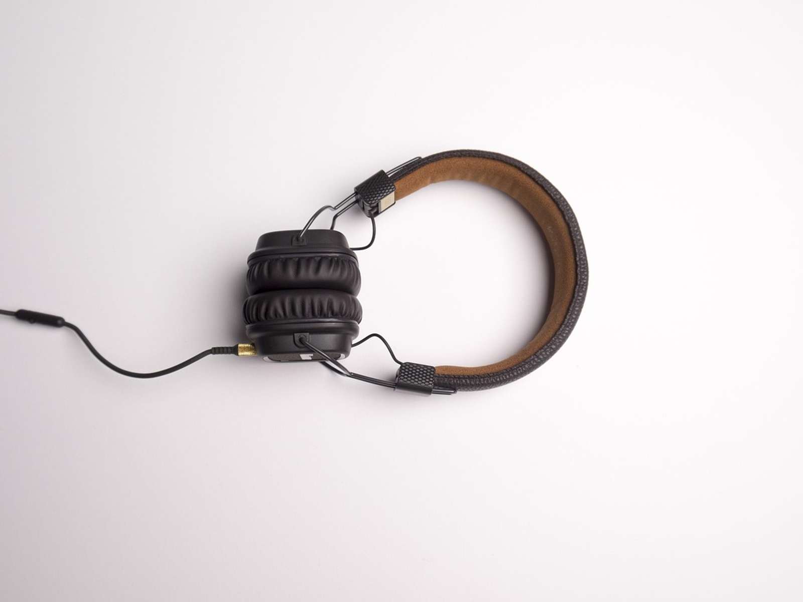A pair of headphones with a cable on a white surface