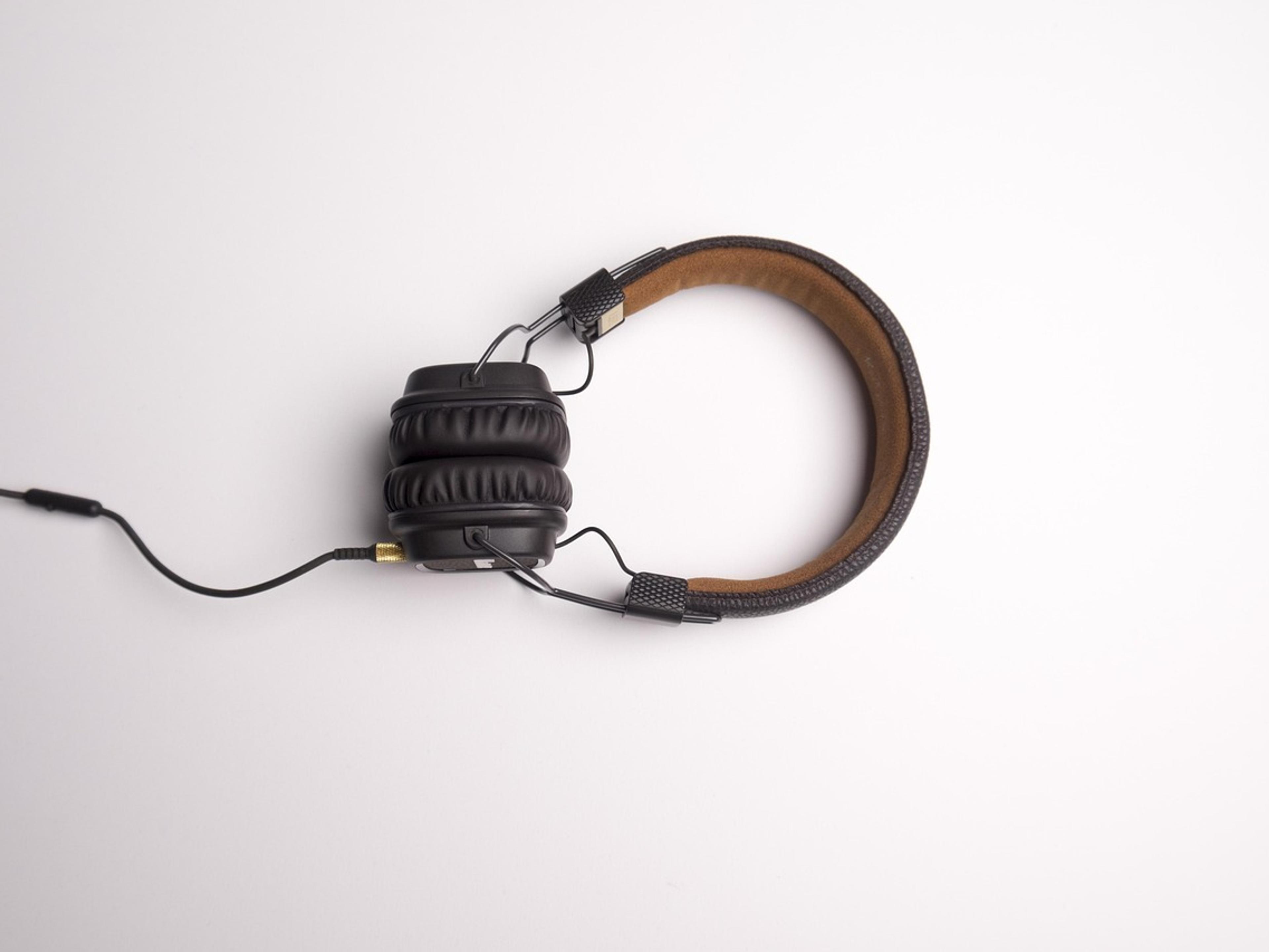 A pair of headphones with a cable on a white surface