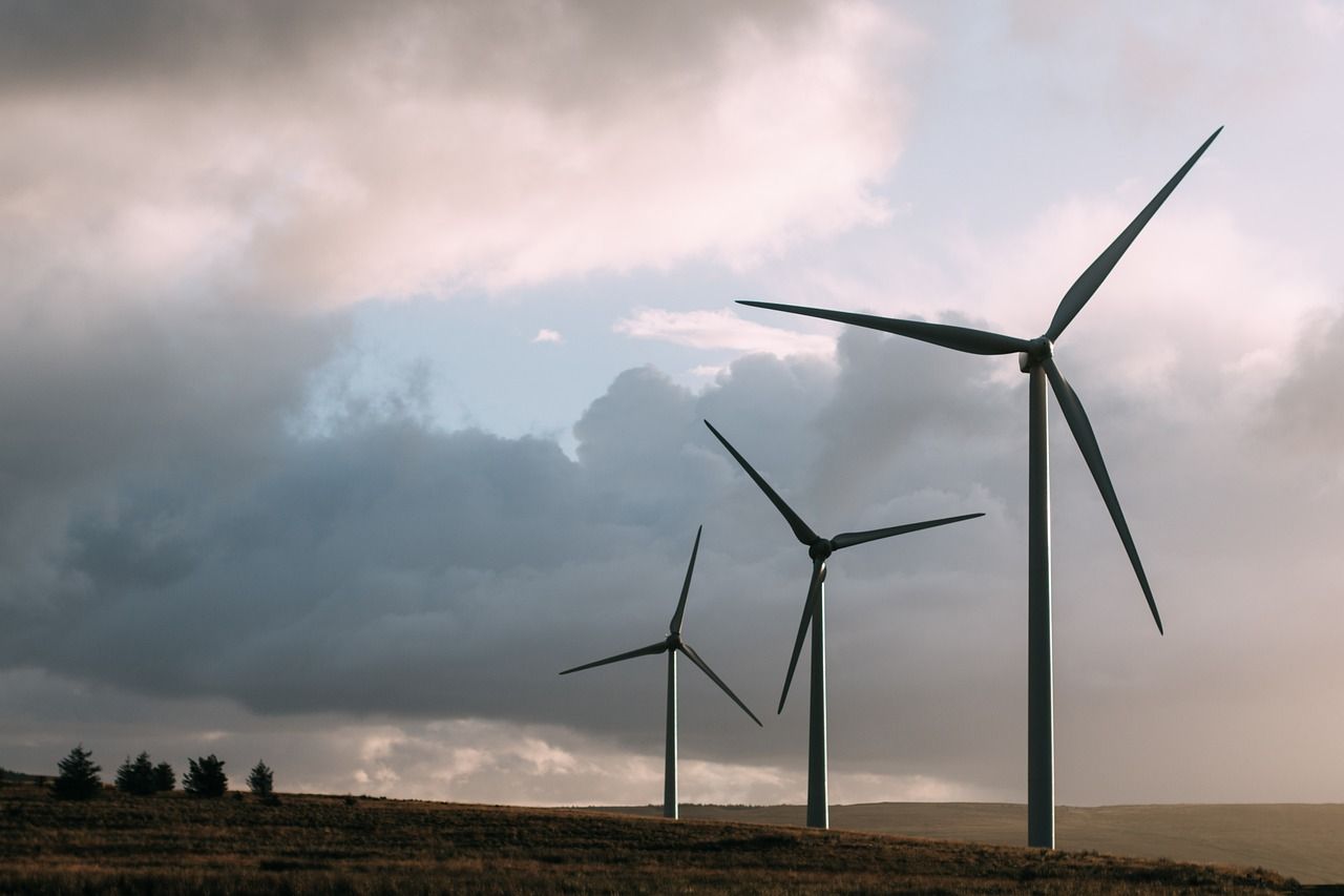 Tall wind turbines against a bright sky