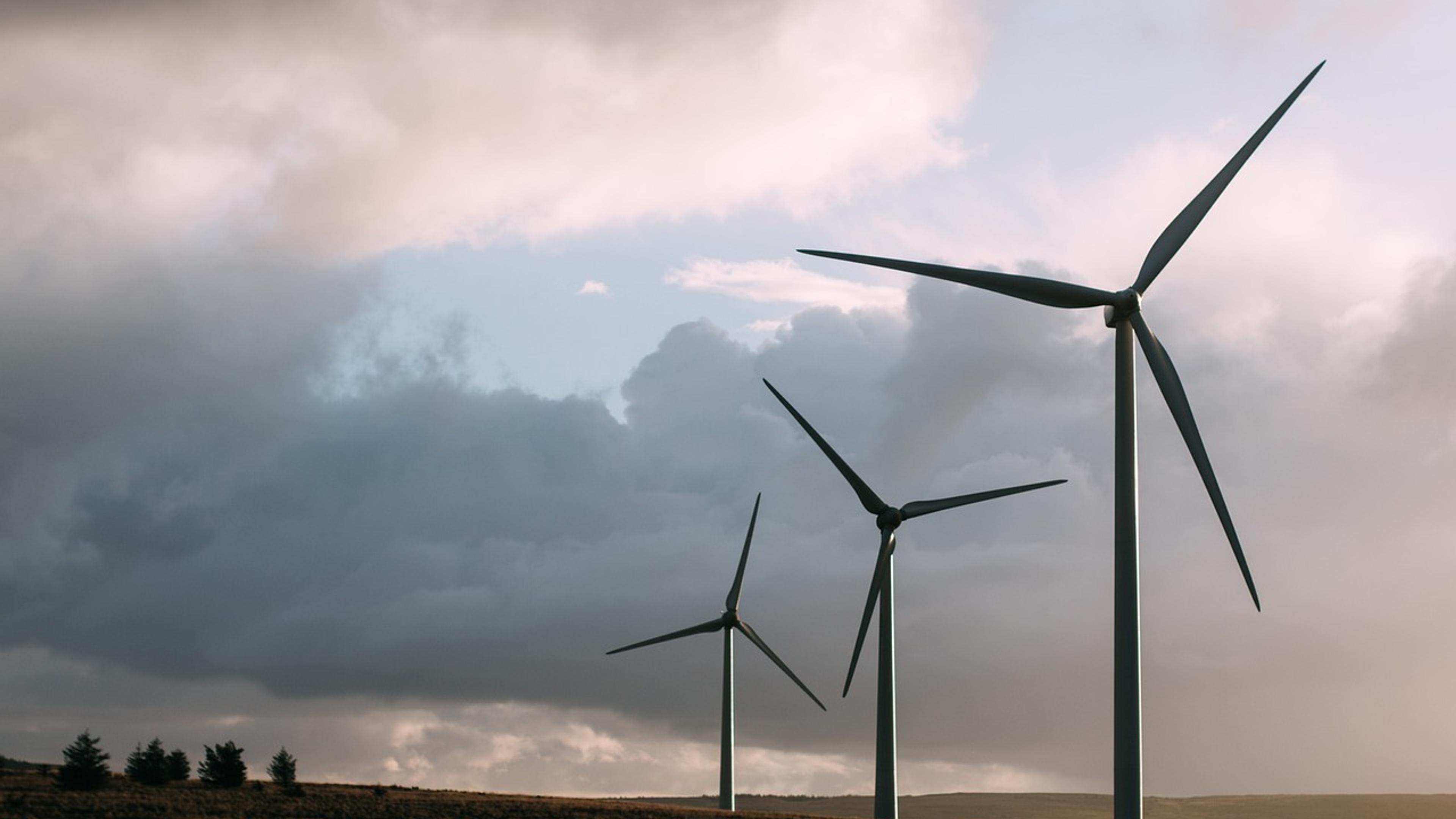 Tall wind turbines against a bright sky
