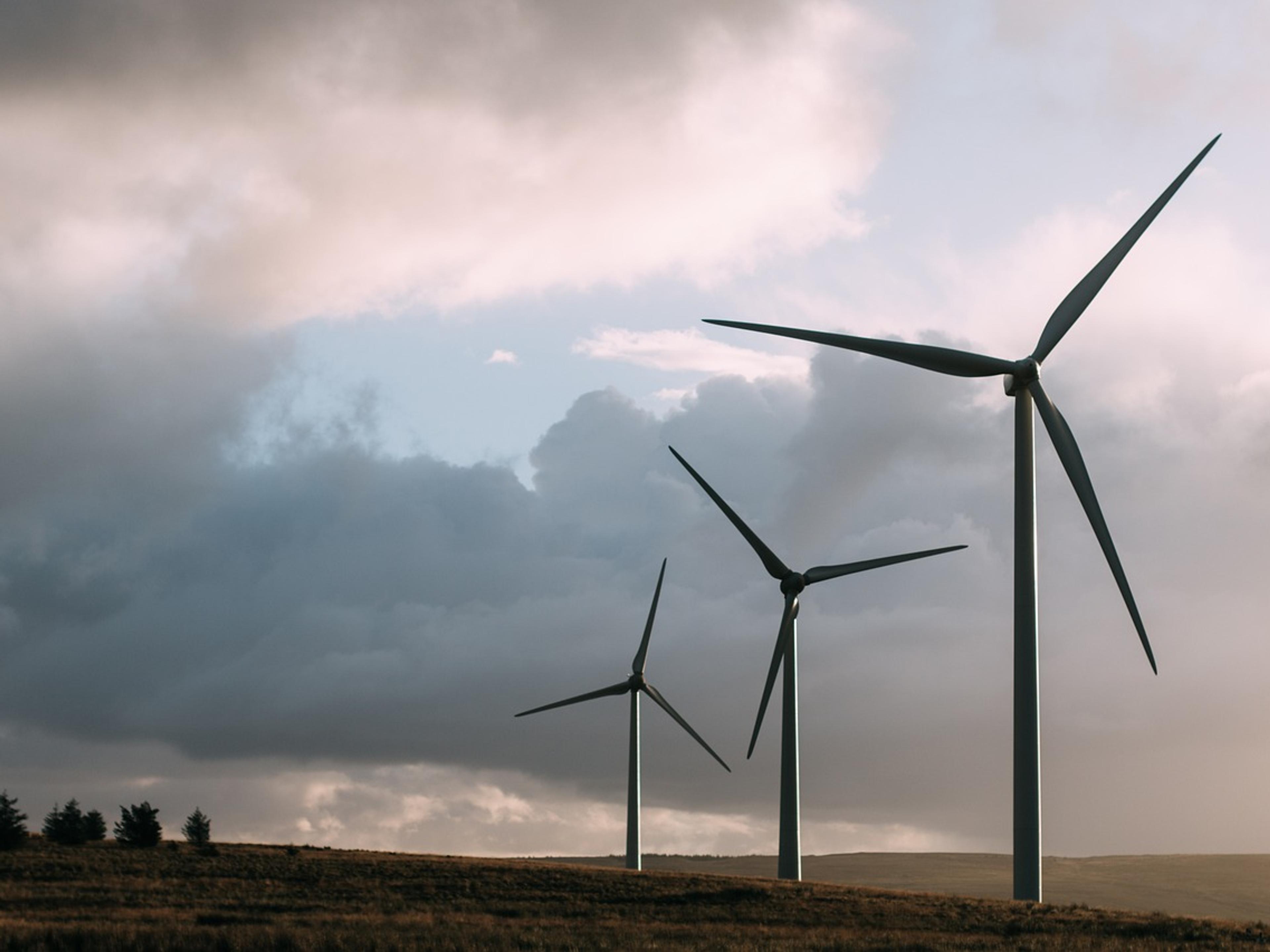 Tall wind turbines against a bright sky