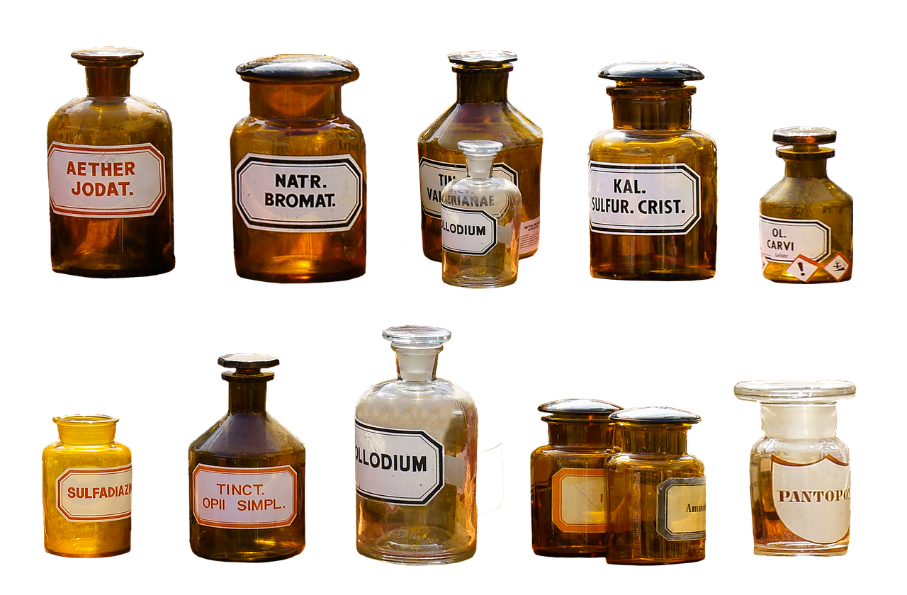 Old labelled glass bottles of chemicals on a white background