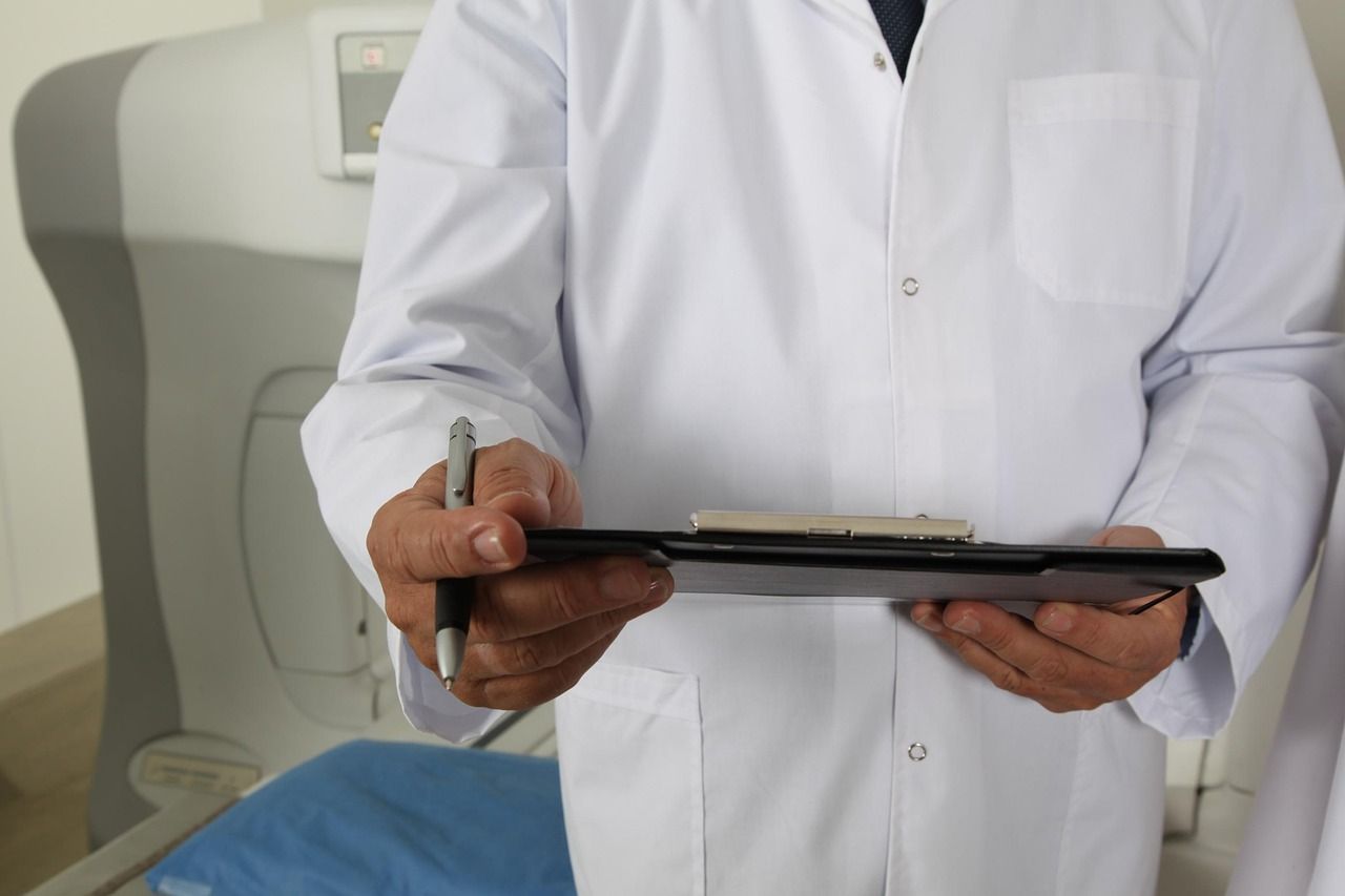 A doctor and patient beside a CT scanner in a hospital