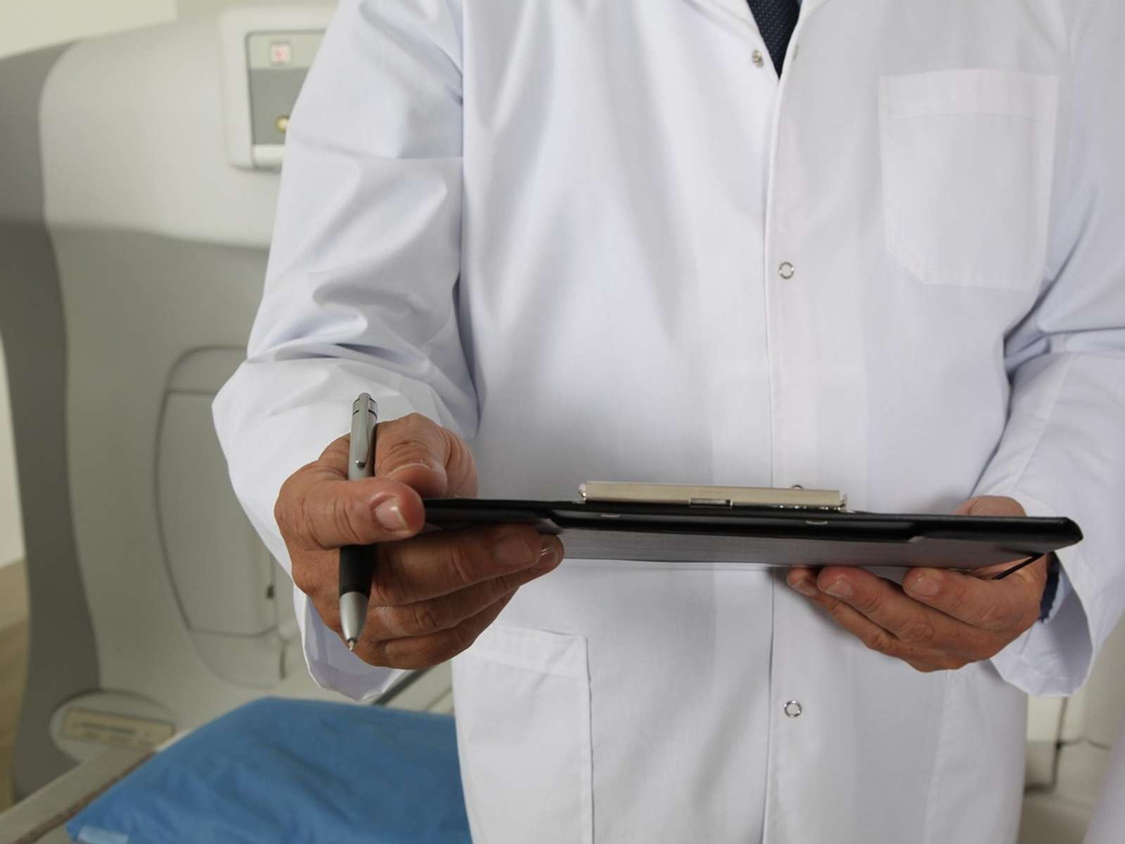 A doctor and patient beside a CT scanner in a hospital
