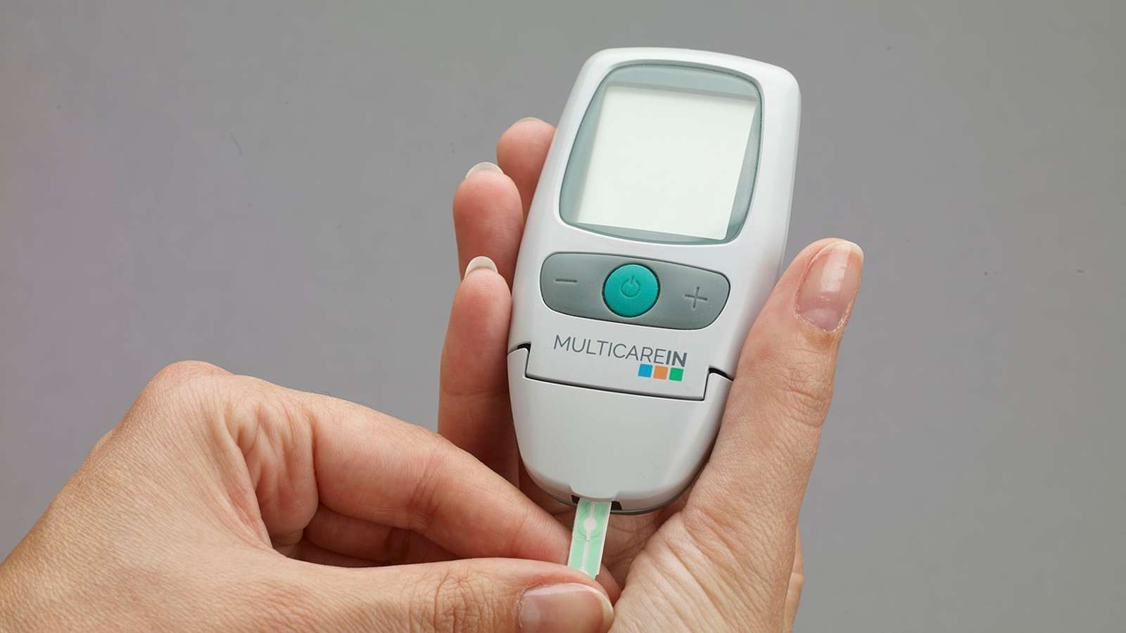 A digital blood glucose meter device lying on a table